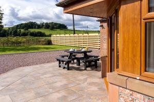 a patio with a table outside of a building at Stanloch Cottage - rural, well equipped, games room, EV in Dumfries +19 photos