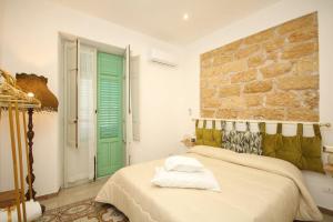a bedroom with a bed and a green door at Donna Carmela in Porticello
