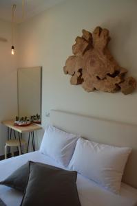 グリファにあるOasi Luxury Apartmentsの白いベッド1台(木製ヘッドボード付)が備わるベッドルーム1室が備わります。
