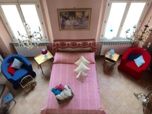um quarto com uma cama e duas cadeiras e janelas em La Stagione dell'Arte Luxe em Camaiore
