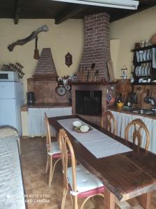 a kitchen with a wooden table with chairs and a fireplace at Casa la centinela in La Guancha