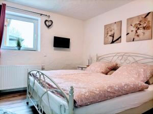 ein Schlafzimmer mit einem Bett und einem Fenster in der Unterkunft Ferienwohnung Schneider in Münk