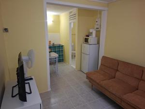 a living room with a couch and a kitchen at Studio Fort-de-France in Fort-de-France