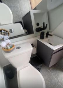 a bathroom with a white toilet and a sink at Pietrasanta Home in Rionegro +23 photos