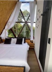 a bedroom with a bed and a large window at Pietrasanta Home in Rionegro