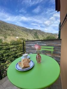 a green table with a plate of food on a balcony at C'era un Voltino Guest House in Borgonovo