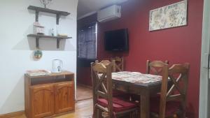 a dining room with a table and chairs and a tv at eldepademarcelo in Plaza Huincul