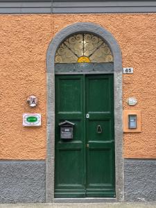 a green door in a building with an orange wall at C'era un Voltino Guest House in Borgonovo