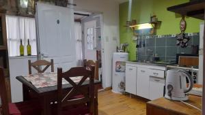 a kitchen with a table and a kitchen with green walls at eldepademarcelo in Plaza Huincul