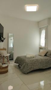 a white bedroom with a bed and a skylight at CThomeRimini, appartamento Rimini Miramare in Rimini