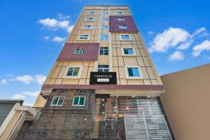 a tall building with a sign on it at Super Townhouse Kokapet Formerly Aarian Tej Nilayam in Hyderabad