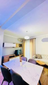 een eetkamer met een witte tafel en stoelen bij Blloku Luxury 2 bedroom apartment in Tirana