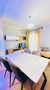 een eetkamer met een witte tafel en stoelen bij Blloku Luxury 2 bedroom apartment in Tirana