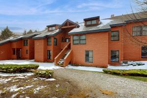 a large brick building with snow on the ground at Trail Creek 72 in Killington