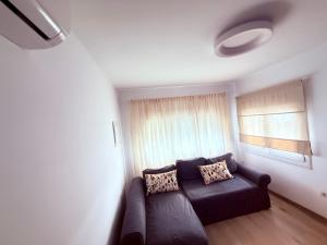 Una sala de estar con un sofá y una ventana. en La casa de la playa, en Playa Quemada