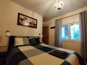a bedroom with a black and white bed and a window at Apartamento El Corazón de Gredos in Arenas de San Pedro