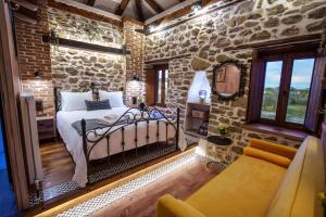 a bedroom with a bed in a stone wall at Archontiko Theofanous 1915 in Tríkala