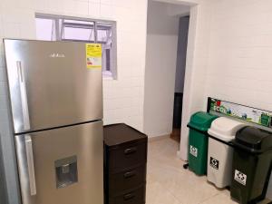 a kitchen with a stainless steel refrigerator and trash cans at Casa Bella Vista in Bogotá