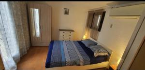 een slaapkamer met een bed, een ladekast en een raam bij Villa pied dans l eau in Cala dʼOro