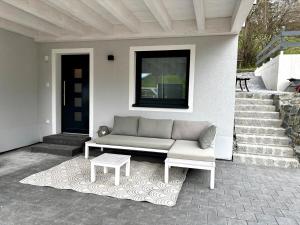 a couch on a porch with a table and stairs at Bergzauber in Pfronten