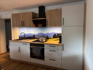 a kitchen with white cabinets and a stove top oven at Bergzauber in Pfronten