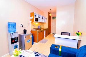 a living room with a kitchen with a counter and a kitchen at Enac Homes - Gold Edition - Decorous Superior Executive Studio - Kiambu Road in Nairobi