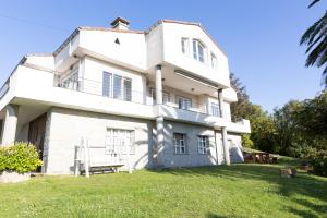 a large white house with a yard at Mar Beach House in Bareyo