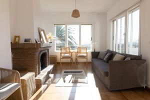 a living room with a couch and a fireplace at Mar Beach House in Bareyo