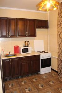 a kitchen with a stove and a microwave at Апартаменты на пр Победы OrenRoom in Orenburg