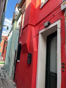 un edificio rojo y blanco con una puerta en Casa Gemmas Daydream, en Burano