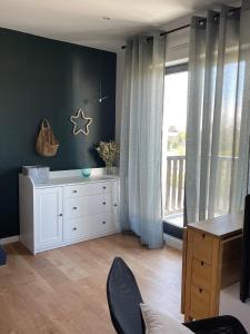 a living room with a white dresser and a window at Magnifique appartement avec mezzanine prés Thalasso in Cabourg
