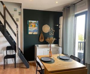 a dining room with a table and black walls at Magnifique appartement avec mezzanine prés Thalasso in Cabourg