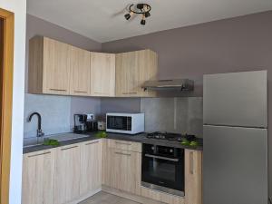 a kitchen with wooden cabinets and a white refrigerator at Manahau Lodge in Pirae
