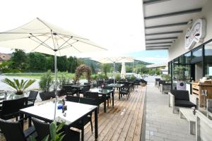 Peggau的住宿－拉庫齊納酒店及餐廳，室外餐厅设有桌椅和遮阳伞。