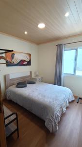Un dormitorio con una cama y una ventana grande. en Casa Belém 5, en Ponta Delgada