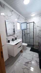 Un baño blanco con lavabo e inodoro. en Casa Belém 5, en Ponta Delgada 25 fotos más