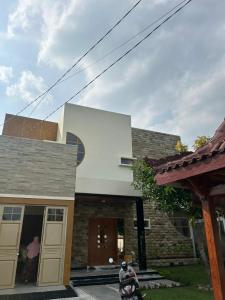 une maison avec une moto garée devant elle dans l'établissement Nurrindah Homestay, à Banyuwangi