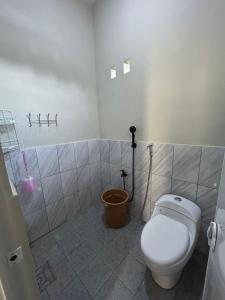 une salle de bain avec toilettes dans une pièce carrelée dans l'établissement Nurrindah Homestay, à Banyuwangi