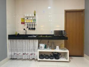 a kitchen with a counter and a sink and a microwave at Loft com ar condicionado in Goiânia