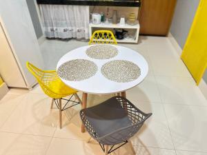 a white table and chairs in a room with a kitchen at Loft com ar condicionado in Goiânia +1 photo