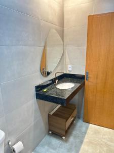 a bathroom with a sink and a mirror at Loft com ar condicionado in Goiânia