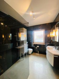 a bathroom with a sink and a toilet and a window at Ferienwohnungen Orchidee in Preußisch Oldendorf