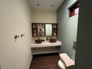a bathroom with two sinks and a person taking a picture at Seaview Oasis in Gated Community and Walk to Beaches in Willemstad