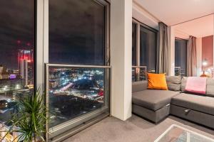 een woonkamer met een bank en een groot raam bij 25 World Famous Rotunda 18th floor skyline views in Birmingham