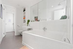 een witte badkamer met een bad en een toilet bij 25 World Famous Rotunda 18th floor skyline views in Birmingham +35 foto's