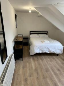 a bedroom with a bed and a wooden floor at Spacious 3-Bed Flat in Jesmond in Jesmond