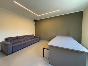 un soggiorno con un divano e un tavolo di Astor Suites a Campinas