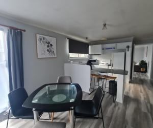 a kitchen and dining room with a table and chairs at Zeehan 3 bedroom house in Zeehan +4 photos