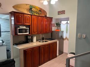 una cucina con lavello e microonde di Enchanting 3 BR 2 Bath Condo in the Heart of Jaco a Jacó