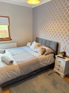 a bedroom with a bed and a night stand at Newly Refurbished 2 Bedroom flat on NC500 route in Wick